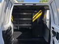Interior of a 2019 GMC Savana van featuring metal shelves and a black storage cabinet with yellow stripes