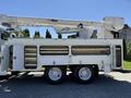 A 2013 International 7400 truck equipped with an Altec aerial lift system featuring a raised boom for utility work