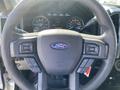 Steering wheel of a 2018 Ford F-150 with control buttons and the Ford logo prominently displayed