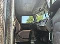 Interior view of a 2008 Peterbilt 340 truck showing the driver's seat dashboard and controls with the sunlight illuminating the cabin
