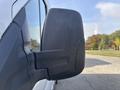 Close-up of the side mirror of a 2016 Ford Transit 150 showing its black surface and angular design