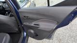 Interior door panel of a 2019 Nissan Kicks featuring controls for windows and locks with a speaker in the lower section
