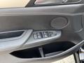 BMW X3 door panel featuring control buttons for windows and mirrors along with a speaker and textured surface