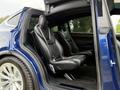 Interior view of a 2020 Tesla Model X showing black leather seating in the rear with two individual seats designed for comfort and space