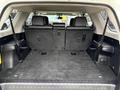 The interior of a 2018 Toyota 4Runner showcases a spacious cargo area with black carpeting and seatbacks folded down for maximum storage capacity