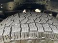 Close-up of a tire with deep treads from a 2013 Ford F-250 SD showcasing its rugged surface and design