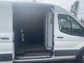 A 2024 Ford Transit with an open sliding door revealing a spacious cargo area devoid of any contents