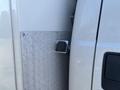 A side view of a 2011 Ford F-550 showing a fuel filler cap and a section of diamond plate metal paneling