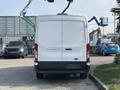 A white 2016 Ford Transit 150 cargo van viewed from the rear with a plain back door and no visible logos or markings