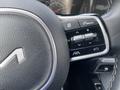 Close-up of the steering wheel controls of a 2022 Kia Sorento featuring buttons for audio and drive mode adjustments