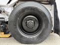 A large black tire mounted on a vehicle wheel featuring a central hub and visible tread pattern designed for traction