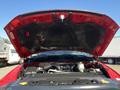 A red 2015 RAM 2500 with its hood raised exposing the engine compartment and various mechanical components