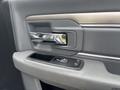 A gray door panel of a 2016 RAM 5500 featuring a chrome handle and controls for the windows and locks