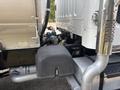 A 2010 Freightliner M2 106 truck with a visible engine compartment and a black storage box situated near the base of the vehicle