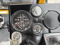 The image shows the control panel of a 2004 Bombardier SW48 featuring gauges for fuel, oil, temperature, and volts along with a key ignition switch