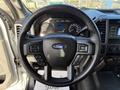 Steering wheel of a 2020 Ford F-550 featuring buttons for audio control and cruise settings with the Ford logo in the center