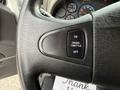 Close-up of a black steering wheel with a control button labeled ON CRUISE THROTTLE OFF