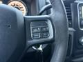 Close-up of the steering wheel controls of a 2018 RAM 5500 featuring buttons for on/off cruise control and settings