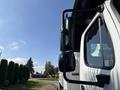 A 2019 Freightliner M2 106 truck with a side mirror and arm clearly visible in the foreground