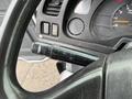 Close-up of the steering wheel controls in a 2007 GMC F7500 featuring indicators cruise control and dashboard gauges
