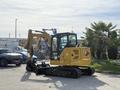 A 2022 Caterpillar 306 compact excavator with a yellow body and black tracks features a hydraulic arm with a bucket attachment