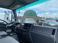 Interior view of a 2019 Isuzu NRR showing the driver's seat and dashboard with controls and a steering wheel