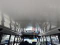 Interior view of a 2011 Freightliner B2 bus showing the ceiling lights and spacious overhead area