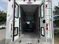 A 1994 GMC Vandura 3500 with open back doors revealing an empty cargo space and a single seat in the center