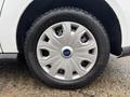 A close-up view of a silver wheel with a distinct design mounted on a black tire from a 2019 Ford Transit Connect