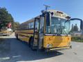 A yellow 2006 Thomas Saf-T-Liner HDX school bus with an open door and large windows parked on a road