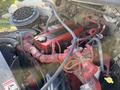 A 2011 Freightliner M2 106 engine featuring red components and numerous wires and hoses throughout the engine compartment