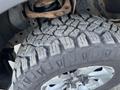 Close-up of the rugged tire of a 2014 Ford F-150 showcasing deep tread patterns and a metallic wheel rim