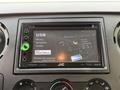A JVC car stereo display showing options for USB, music, artwork, and video with an iPod connection indicator and volume control knobs