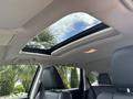 A 2014 Honda CR-V featuring a panoramic sunroof and black leather seats with a view of palm trees outside