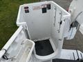 A white bucket platform of a 2005 Freightliner M2 106 truck with signs indicating safety warnings and instructions for use