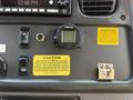 Dashboard of a 2022 Freightliner B2 featuring various control switches a digital display and caution warning labels