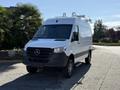 A 2023 Mercedes-Benz Sprinter 2500 van with a white exterior and black accents parked on a pavement