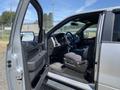 A 2014 Ford F-150 with an open driver's side door showcasing the interior and driver's seat