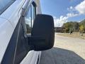 A side mirror of a 2018 Ford Transit-350 showing a black housing and attached to a white van body