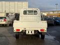 A 2008 Suzuki Carry white small truck viewed from the rear with a flatbed and visible tailgate