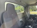 Interior view of a 2013 International WorkStar featuring two gray fabric seats positioned in the cabin with a console visible between them