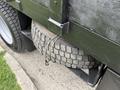 A 2020 Ford F-550 with a spare tire mounted on the rear tailgate using a metal clasp and a rubber strap
