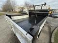 A 2015 Ford F-350 truck with a flatbed design showing metal edges and a black surface ready for hauling or transport