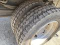 Close-up of a pair of worn tires on a vehicle showing visible tread patterns and dirt on the rims