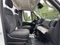 Interior view of a 2023 RAM Promaster 3500 showing two upholstered front seats and a dashboard with controls and storage compartments