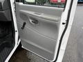 A 2007 Ford E-350 van door in light gray featuring a handle crank a speaker grille and a smooth panel design