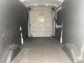 A 2024 Ford Transit van interior showing spacious empty cargo area with dark walls and a single rear door