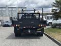 A 2017 Ford F-550 truck with a black flatbed and visible red and orange lights on the rear