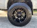 A close-up of a black wheel and tire on a 2018 RAM 3500 showing a silver and black alloy wheel with a bold treaded tire