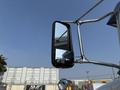A side mirror of a 2020 Peterbilt 330 truck reflecting the view alongside the vehicle